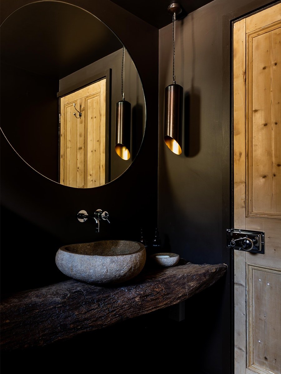 Cambray House dark-toned cloakroom with stone basin on live-edge timber shelf and copper pendant light